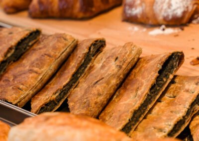 Torta salata farcita artigianale alle erbe esposta in vetrina